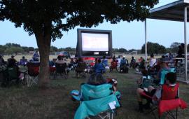 Movie screen and people at the park