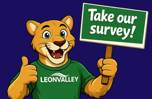 animated mountain lion holding a sign saying Take Our Survey dressed in green Leon Valley shirt with thumbs up