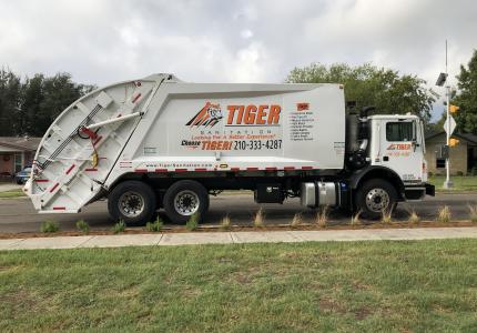 image of a Tiger Sanitation dump truck on a roadway