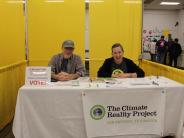 Climate Reality Project booth with man and woman smiling sharing information