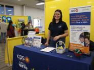 CPS energy female representative at booth for EWL day event sharing information