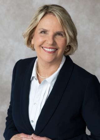 Mayor Chris Riley headshot wearing a white collar button up with navy blue blazer