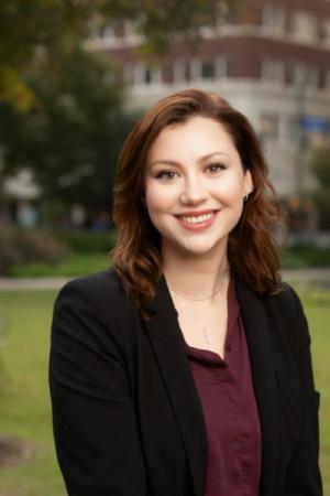 Head shot of Sarah Woeppel in maroon blouse and black blazer