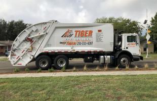 image of a Tiger Sanitation dump truck on a roadway